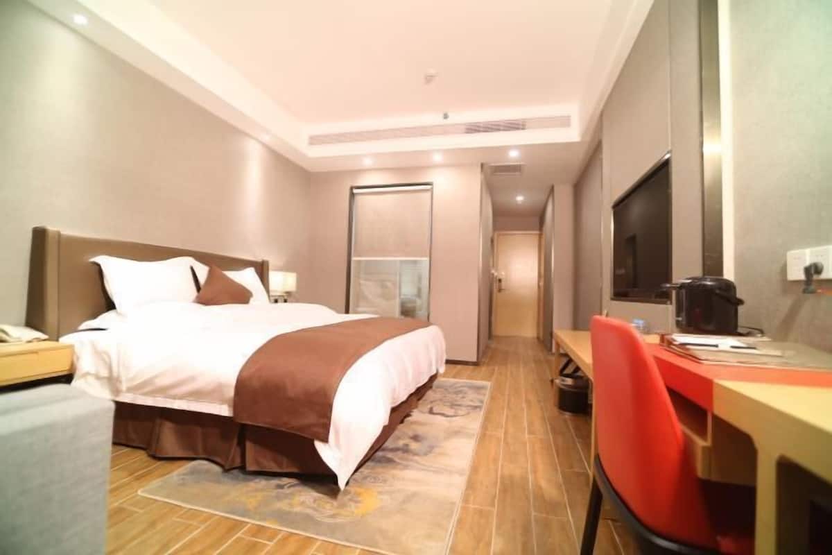 Hotellihuoneessa on sänky, työpöytä, tuoli, televisio ja pieni keittiö.