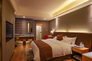 Hotelkamer met een bed, nachtkastje, lamp en uitzicht op een schuifdeur.