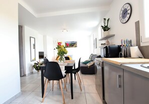 Relax in this stylish apartment with a comfortable sofa, dining table, and modern kitchen amenities.