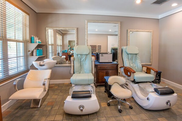 A well-lit room with three massage chairs, a sink, and a mirror.