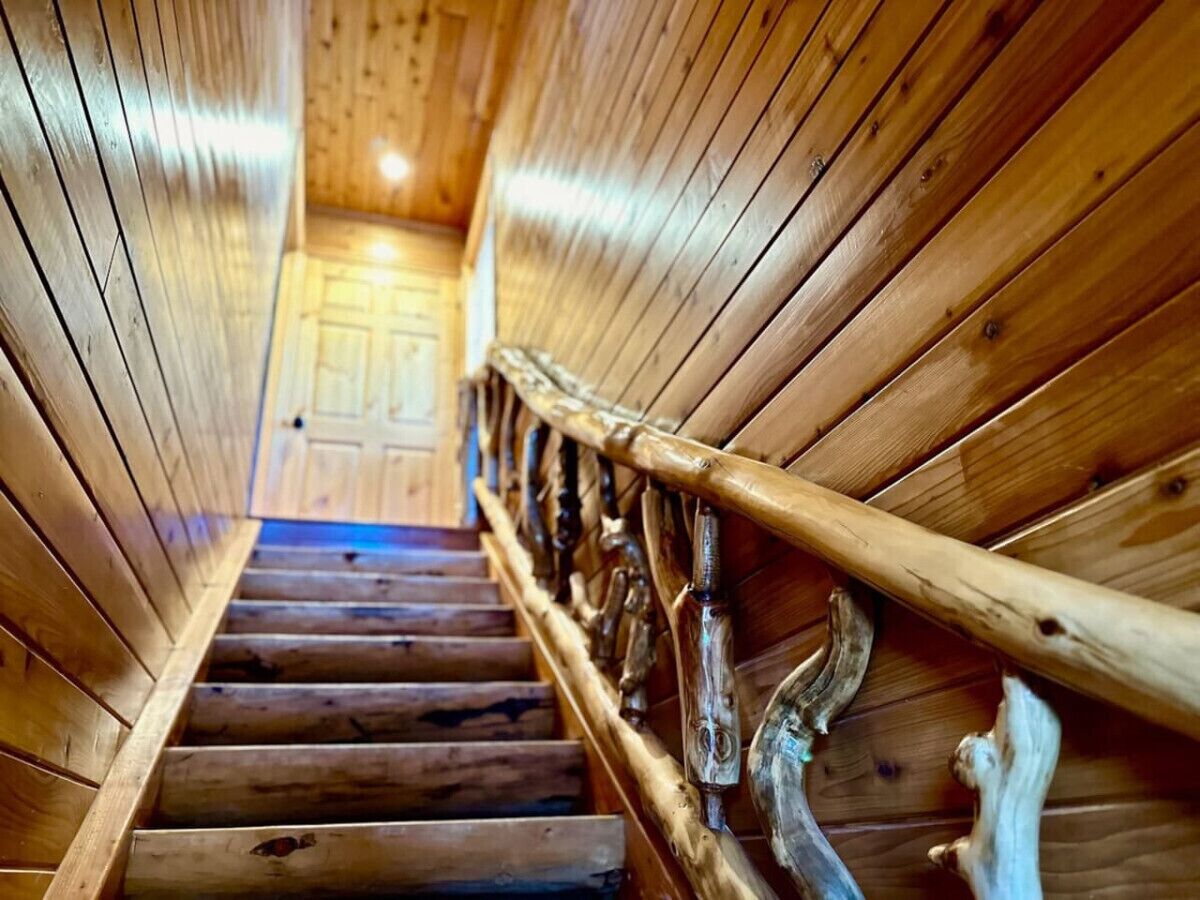 A wooden staircase with a metal railing inside a building.