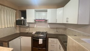 Departamento básico | Cocina privada | Refrigerador con congelador, microondas, horno y lavavajillas