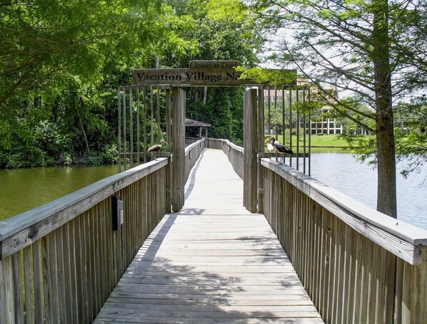A wooden bridge leading to a closed gate labeled 'Vacation Village North.'