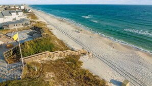 Una proprietà sul lungomare con spiaggia sabbiosa, un molo di legno che conduce alla riva e vista sull'oceano.