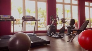 Un gimnasio con cintas de correr, elípticas y pelotas de ejercicio.