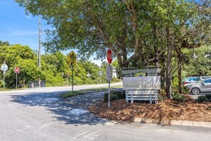 A stop sign, a pedestrian crossing sign, and a sign for Redfish Village.