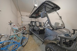 A garage with a golf cart and a bicycle.