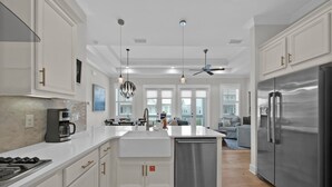 Una cocina moderna con armarios blancos, electrodomésticos de acero inoxidable y una isla central.