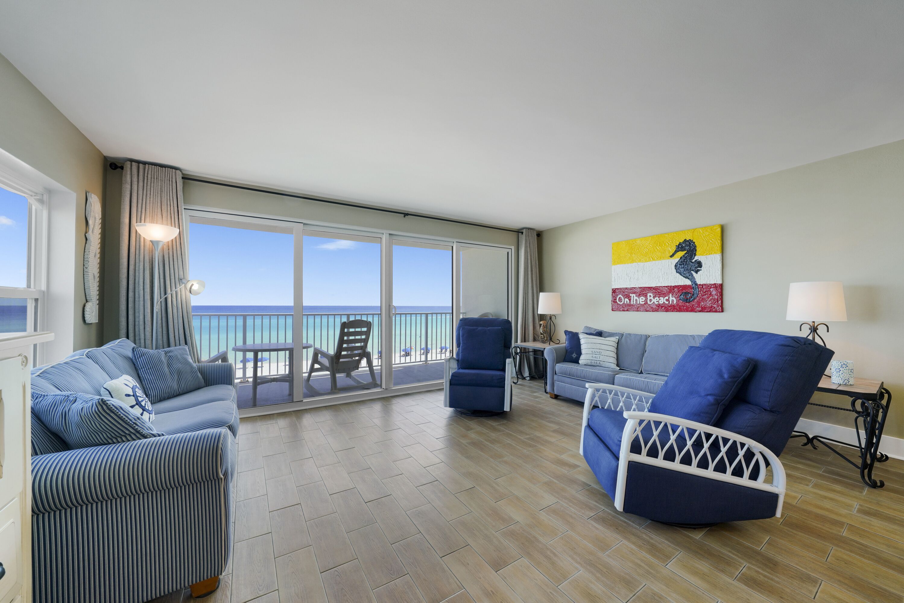 This spacious beachfront living area offers panoramic views of the Emerald Coast through large sliding glass doors, creating the perfect place to relax after a day on the beach.