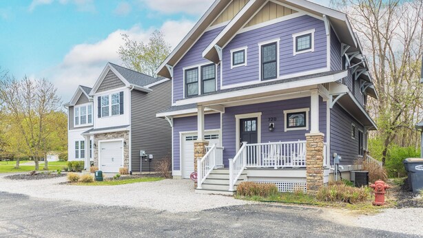A two-story house with a front porch and a garage. - Blueberry Beach House indoor pool, hot tub (South Haven)