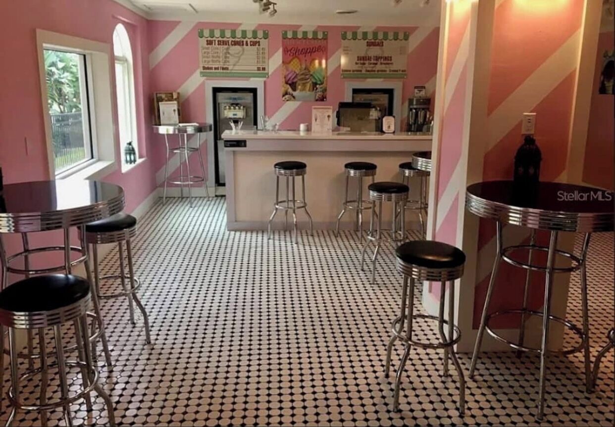 Un espace bar avec des tabourets, un comptoir et un sol à motifs.
