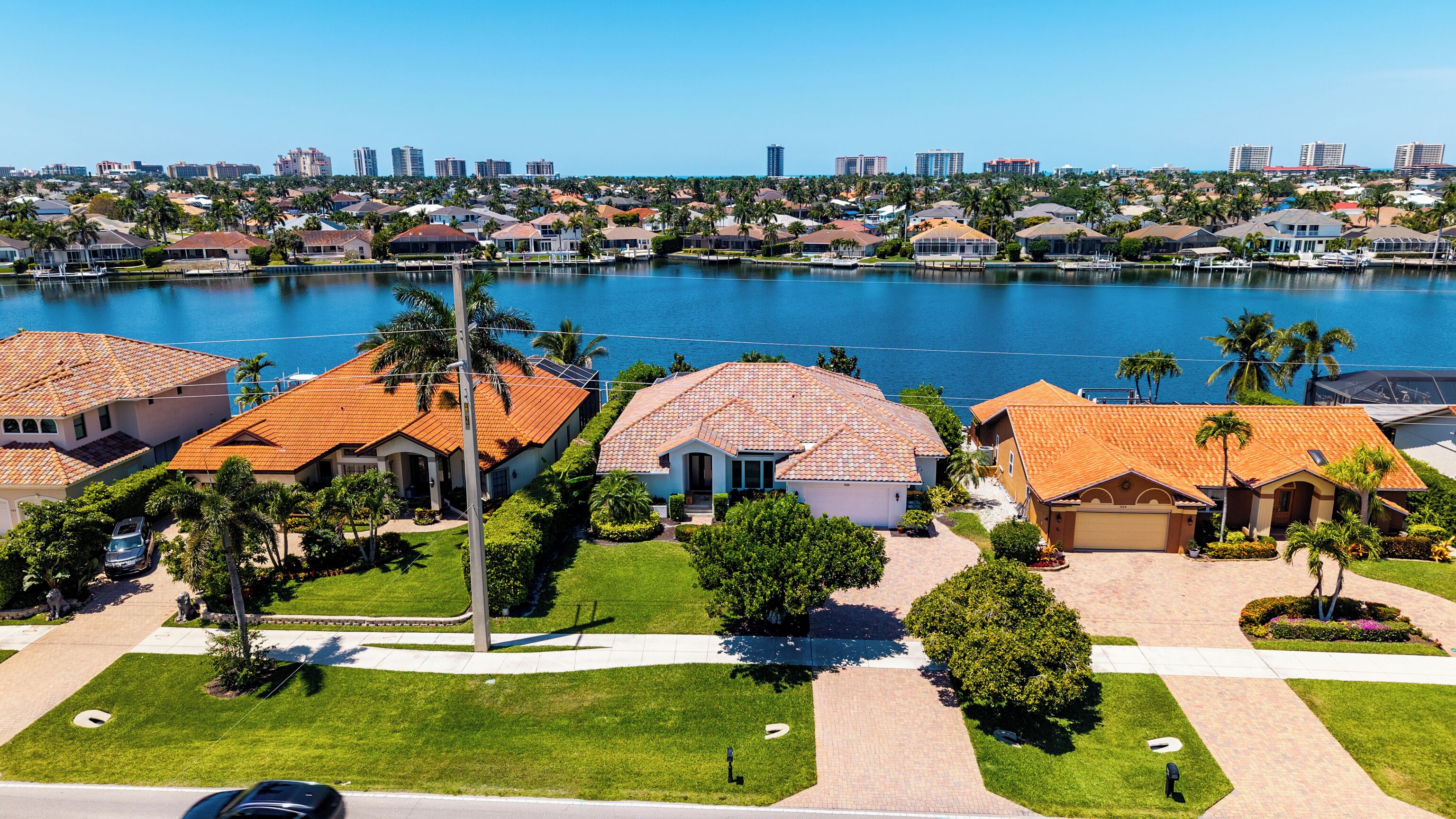A residential area with houses, a marina, and a city skyline in the background.