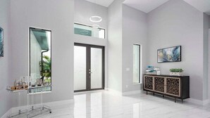 A spacious, modern interior with a large glass door, a minimalist console table, and a clean, white floor. - Paradiso - Modern Style Vacation Villa (Cape Coral)