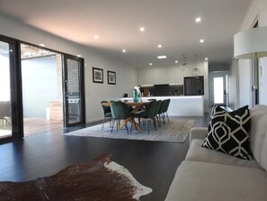 A modern living room with a dining area, a sofa, and a rug.