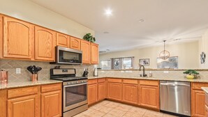 A kitchen with wooden cabinets, stainless steel appliances, and a granite countertop.