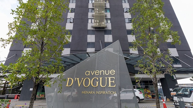 Exterior del hotel Avenue D'Vogue con un diseño moderno, que presenta una entrada destacada y vegetación circundante.