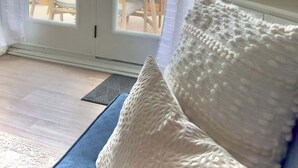 Una habitación con vistas a la playa, un sofá blanco y un mapa enmarcado en la pared.