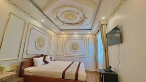 Une chambre d’hôtel équipée d’un lit, d’un bureau, d’une chaise, d’une télévision et d’un téléphone.