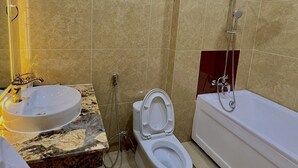 Une salle de bain avec des toilettes, un lavabo et une baignoire.