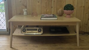 A wooden table with a radio, books, and decorative items.