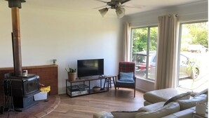 A living room with a fireplace, a television, a sofa, and a chair.