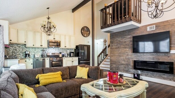 A modern living room with a sectional sofa, a glass coffee table, and a fireplace.
