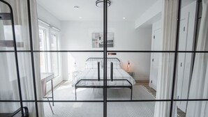 Een moderne slaapkamer met een bed, nachtkastjes en een raam.