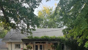 A house with a wooden deck leading to a front door, surrounded by a well-maintained garden and trees. - Charming 3-bedroom house in Decatur City, Minutes from Little River Lake. (Decatur City)