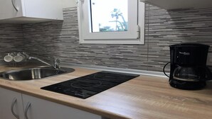 A kitchen with a modern design, featuring a stainless steel sink, a black induction cooktop, and a coffee maker. - Rio Sol - Oasis of privacy (Costa Calma (incl. Urbanización Cañada d)