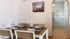 A dining area with a table set for four, chairs, and a painting on the wall. - Rio Sol - Oasis of privacy (Costa Calma (incl. Urbanización Cañada d)