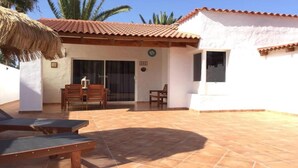 A covered outdoor area with a patio, a table with chairs, and a thatched roof structure. - Rio Sol - Oasis of privacy (Costa Calma (incl. Urbanización Cañada d)