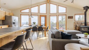 Une cuisine spacieuse dotée d’un grand îlot central, de meubles en bois et d’une cheminée en pierre.