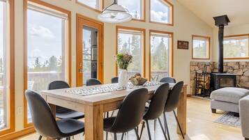 Relax in this inviting room with a dining table, fireplace, and large windows.