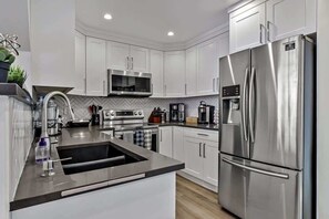 Fridge, stovetop, dishwasher, coffee/tea maker