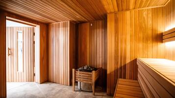 A sauna room with wooden walls and a bench.