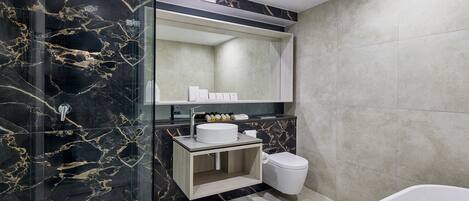 A modern bathroom with a glass-enclosed shower, a white sink, and a toilet.