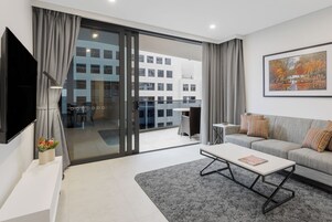 Una sala de estar moderna con un sofá, una mesa de centro y un televisor de pantalla plana.