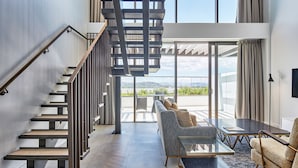 A modern interior with a staircase, a sofa, and a table. - Meriton Suites Canberra (Canberra)