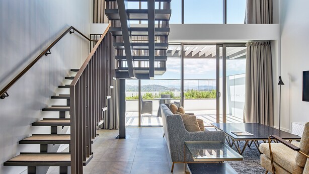 Un interior moderno con una escalera, un sofá y una mesa.