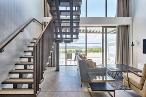 A modern interior with a staircase, a sofa, and a table. - Meriton Suites Canberra (Canberra)