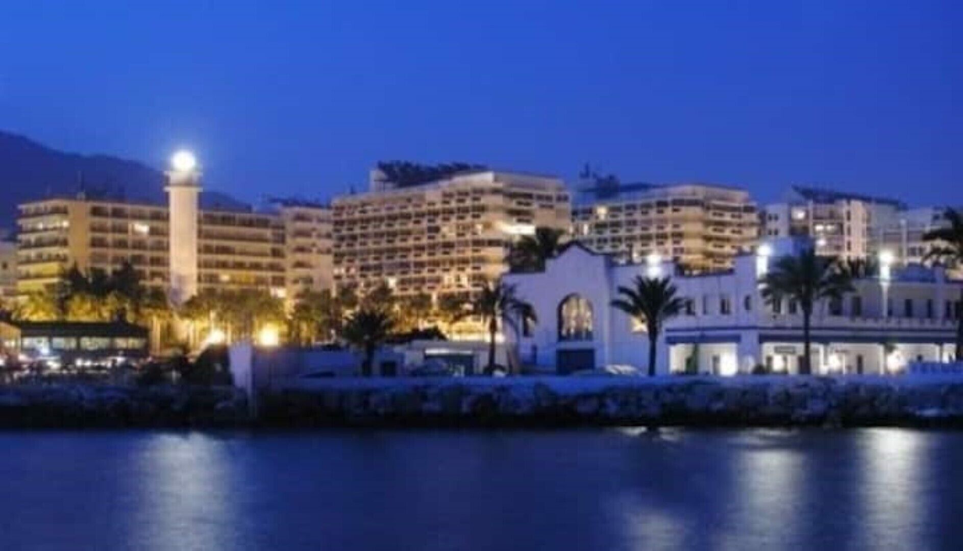 A hotel with multiple buildings, a pool area, and palm trees.