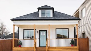 A single-story house with a front porch, a small front yard, and a mailbox.