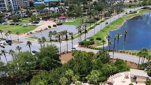 A resort with a large swimming pool, palm trees, and a view of the surrounding cityscape. - Studio Sandestin Resort, 4 mins walk to beach, sleeps 3-4 (Miramar Beach)