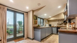 Una cocina moderna con gabinetes grises, un ventanal y vistas al exterior.