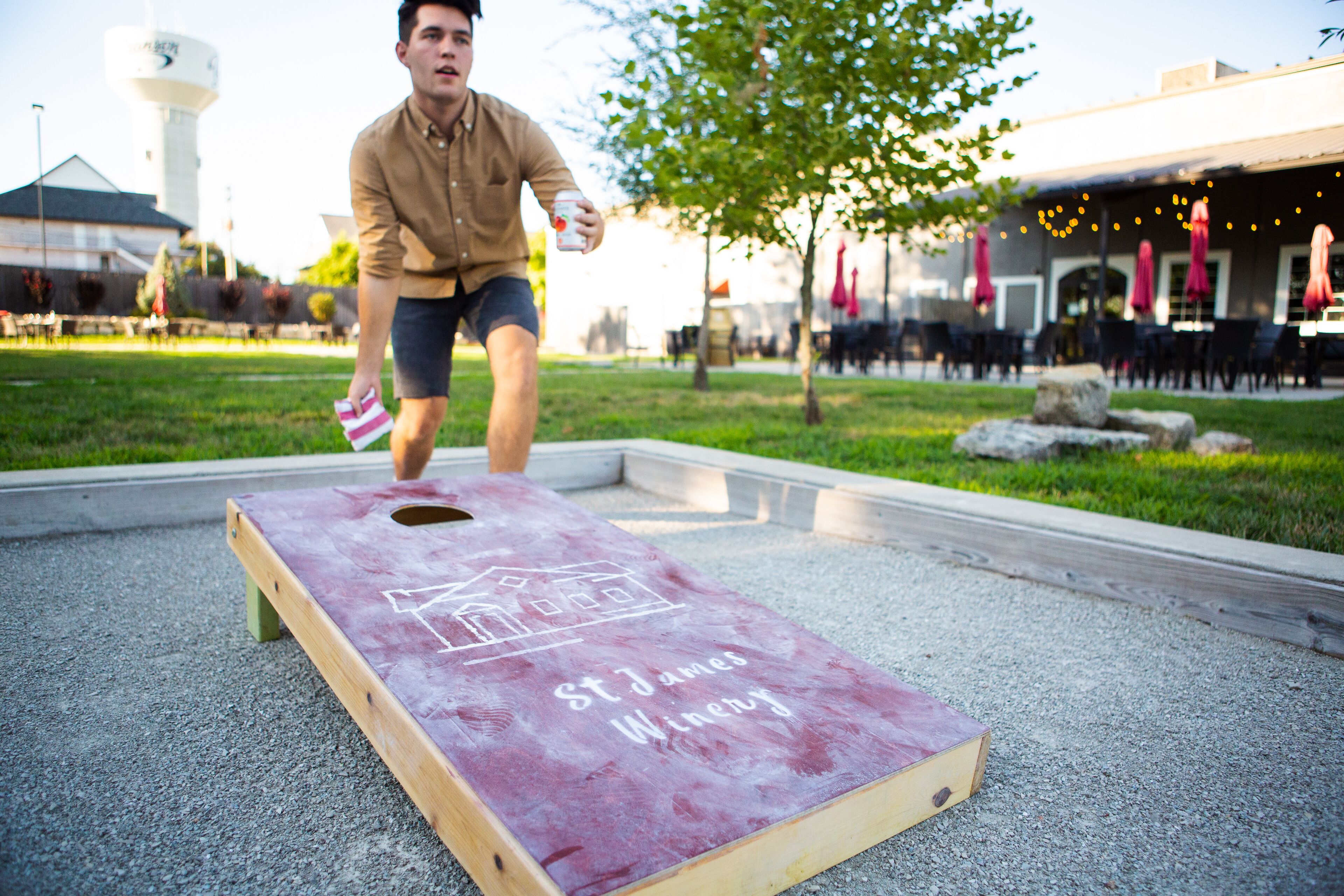 A person playing a game on a wooden board with "St. James Winery" written on it.
