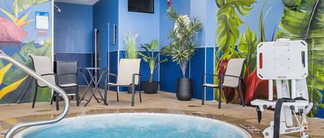 A pool area with a blue wall, chairs, and potted plants.