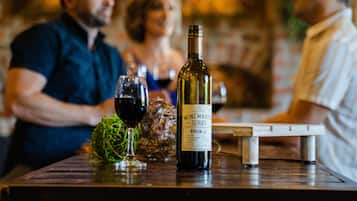 Une bouteille de vin sur une table, avec des verres et un objet décoratif.