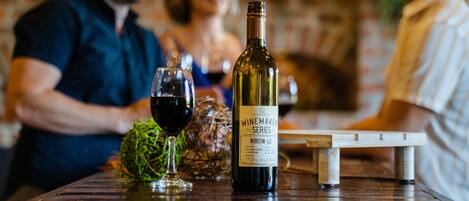 Une bouteille de vin sur une table, avec des verres et un objet décoratif.