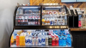 Un distributeur automatique de boissons proposant une variété de produits, notamment des sodas, des jus de fruits et des boissons énergisantes.