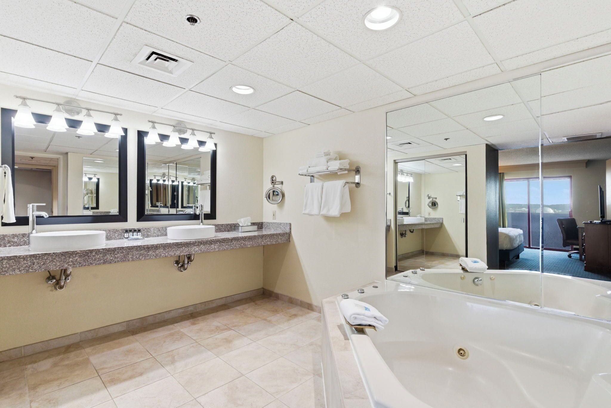 Un baño moderno con dos lavamanos, un espejo grande, una bañera y una zona de ducha.